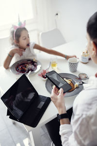 Woman using cell phone at table