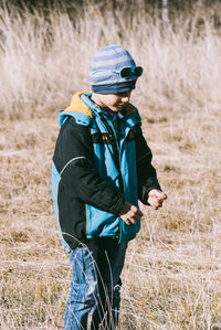 Cute boy standing on grassy field