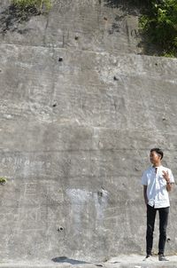 Full length of man standing against wall