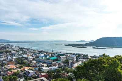 High angle view of city by sea against sky