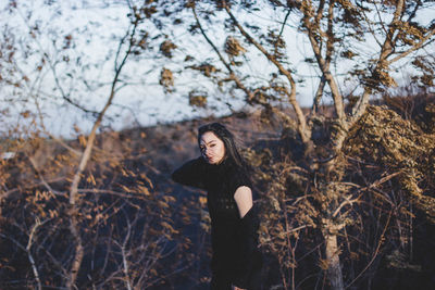 Woman standing on tree trunk