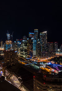 Illuminated buildings in city against sky at night