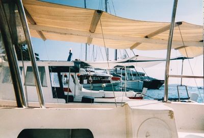 Sailboats moored in sea against sky