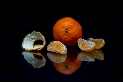 Close-up of fruits on table against black background