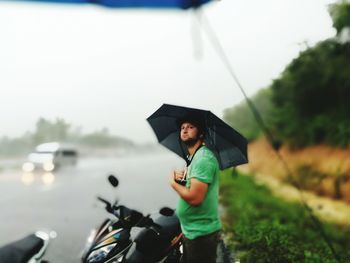 Full length of a smiling man holding rain