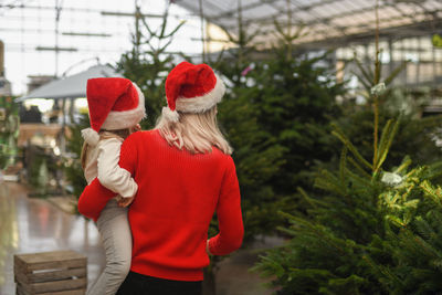 Mother and daughter choose a christmas tree in a shop