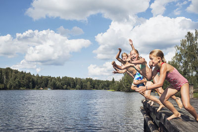 Boys and girls jumping into water