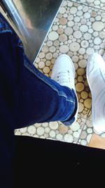 Low section of man standing on tiled floor