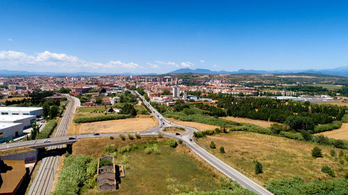 High angle view of buildings in city against blue sky
