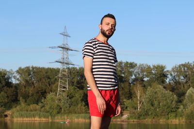 Portrait of smiling man standing against clear sky