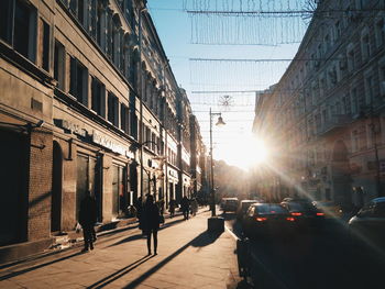 Cars on street in city against clear sky