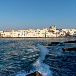 Scenic view of sea and buildings against clear sky