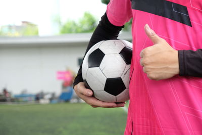 Midsection of woman playing soccer ball on field