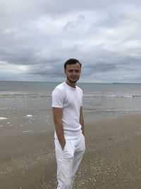 Man standing at beach against sky