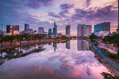 Reflection of buildings in city at sunset