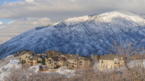 Houses on snowcapped mountain against sky