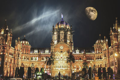 Illuminated buildings in city against sky at night