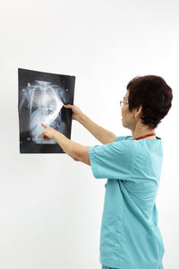 Doctor examining x-ray image against white background