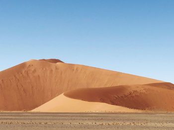 Scenic view of desert against clear blue sky