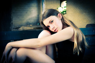 Portrait of girl sitting at in decrepit building