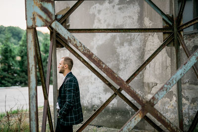 Portrait of man standing against built structure