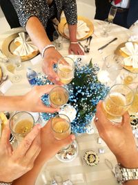 High angle view of people holding drink on table