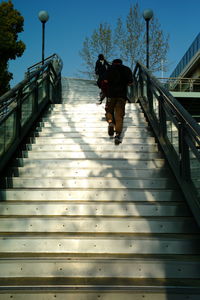 Rear view of woman walking on footpath