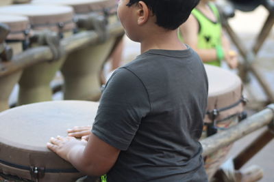 Midsection of boy playing drums