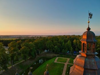 Scenic view of trees and buildings against sky during sunset