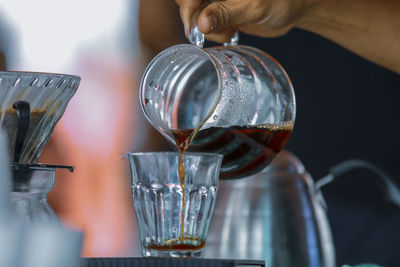 Close-up of hand pouring wine in glass