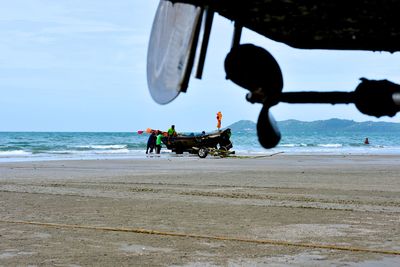 People at beach against sky