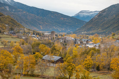 Trees and buildings against mountains during autumn