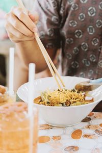 Midsection of man having food at table