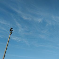 Low angle view of megaphones on pole against sky