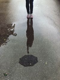 Low section of man standing on puddle