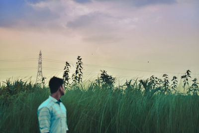 Man on field against sky during sunset