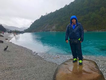 Full length portrait of man standing on mountain against sky