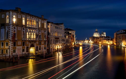 Light trails on street against buildings at night