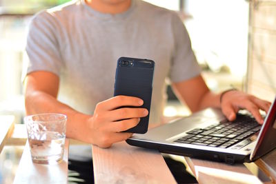 Midsection of man using mobile phone