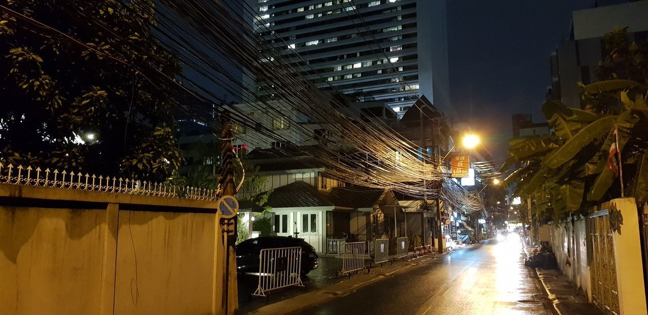 STREET AMIDST BUILDINGS AT NIGHT