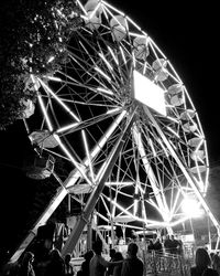 Low angle view of illuminated ferris wheel against sky at night