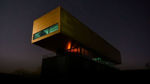 Low angle view of illuminated building against sky at night