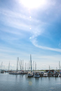 Boats moored at harbor in city against sky