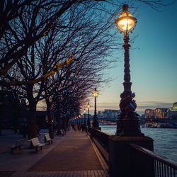 Illuminated street light against sky