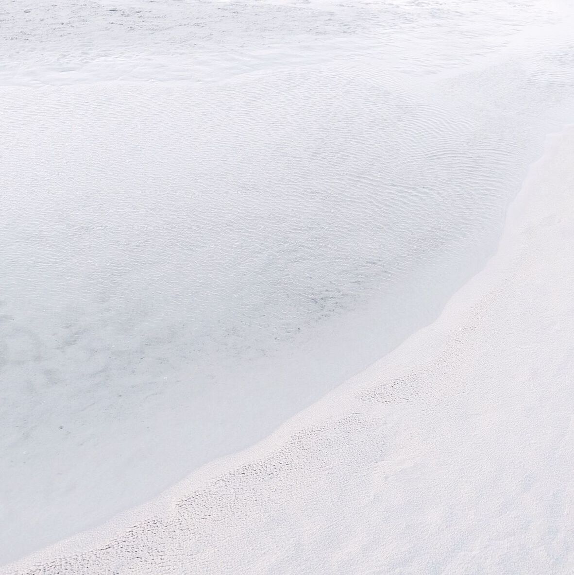 tranquility, beach, sand, snow, tranquil scene, nature, beauty in nature, high angle view, white color, cold temperature, winter, sea, scenics, water, footprint, shore, day, outdoors, no people, idyllic