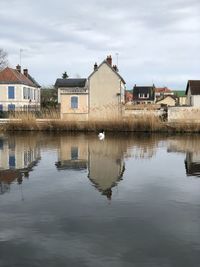 Reflection of buildings in lake against sky