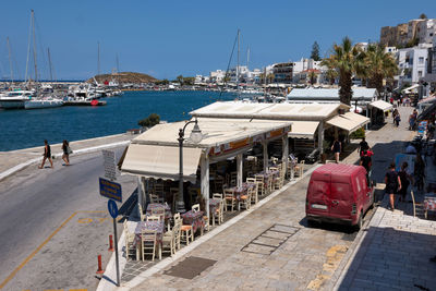 Boats moored at harbor against sky in city