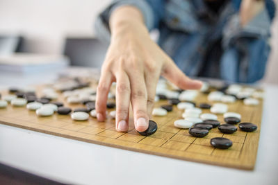 Midsection of man playing board game on table