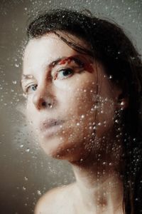 Close-up portrait of wet woman in rain