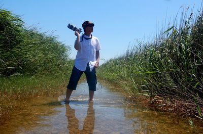 Full length of young woman standing in lake